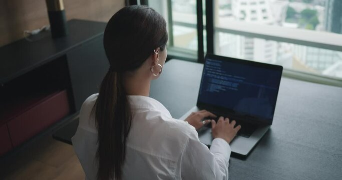 Back rear view female programmer developing app in creative office professional programmer uses working on computer developing app. Focused coder, software engineer developing app, video game.