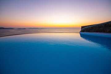 Obraz premium Infinity swimming pool in the villa at sunset time, Mykonos, Greece