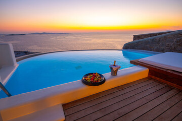 Infinity swimming pool in the villa at sunset time, Mykonos, Greece