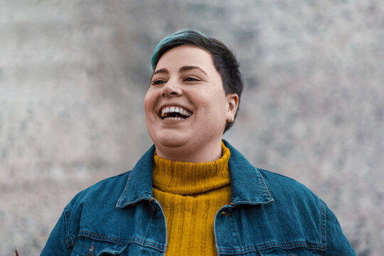 Confident curvy non-binary young person portrait smiling outdoors - LGBTQ empowerment, identity and individuality