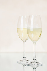 Two champagne glasses on a beige