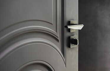 Strict door handle on the interior door. Close-up of the detail. The photo is in gray tones.