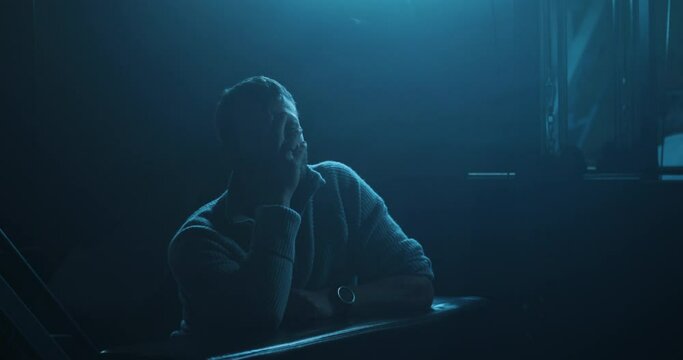 Male sadness, angry man sits in darkness
