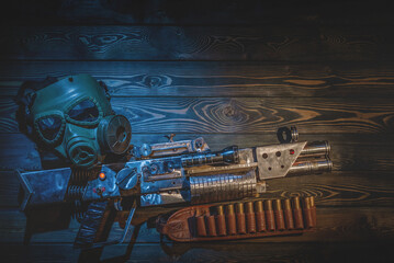 Sci fi post apocalypse pump shotgun and gas mask on the survivor table concept background. - obrazy, fototapety, plakaty