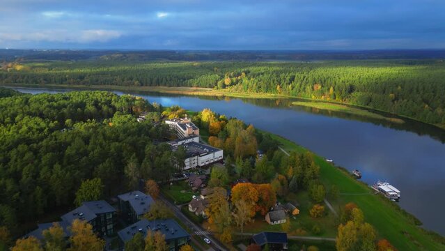 Drone forward revealing Egles sanatorium next to river in Lithuanian panoramic landscape