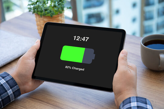 man hands hold computer tablet with charged battery on screen