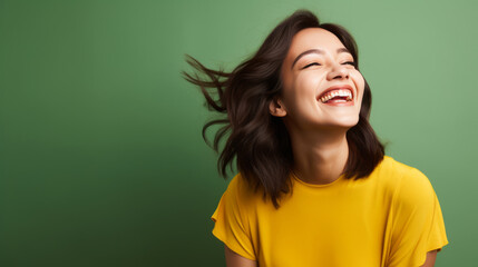 Beaming Eurasian woman in her 20s with green studio backdrop - obrazy, fototapety, plakaty