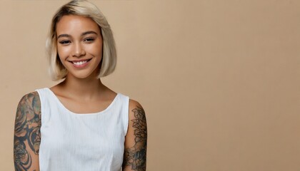 Smiling blond pretty smiling girl beauty female gen z model with short blonde hair beautiful face healthy skin and tattoo looking at camera wearing white top isolated at beige background - obrazy, fototapety, plakaty