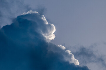 Big stormy clouds in a bright sunny day before sunset