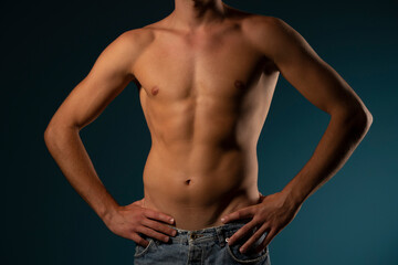 Fototapeta na wymiar the torso of a young athletic guy. concept: the male body after exercise and diet. men's health: shaved breasts on a dark background