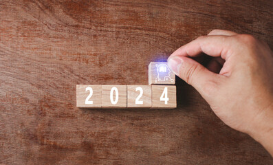 Wooden blocks Happy New Year 2024. Wooden blocks placed on a wood grain background. Unlock all aspects of the AI system To develop technology and Future planning and goals