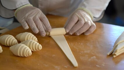 A French pastry chef rolls out croissant dough on the table - Powered by Adobe