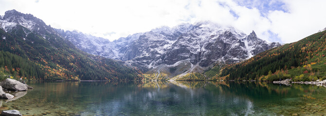 Morskie Oko panorama in Poland's Tatra Mountains. Crystal-clear lake reflecting snow-covered peaks. Vibrant autumn colors paint the landscape. Breathtaking nature scene for travel enthusiasts. © Єгор Городок
