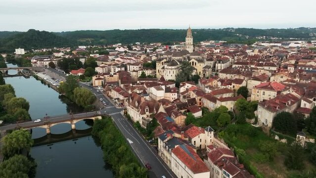 Forward drone travelling along the Isle river, the city of Périgueux with the Roman Catholic Saint-Front cathedral, traffic around the bridge. Dordogne, France