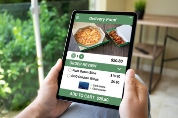 male hands hold computer tablet with food delivery application screen
