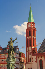 Fototapeta na wymiar Frankfurt, Germany – Old Nikolai Church made of red bricks at Romerberg square, and fountain of justice in historical downtown during colorful sunset, cityscape