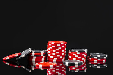 Red and black poker chips on black background