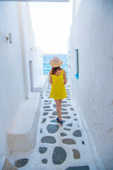 Woman in yellow dress at the Streets of old town Mykonos during a vacation in Greece, Little Venice Mykonos Greece