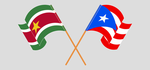 Crossed and waving flags of Suriname and Puerto Rico