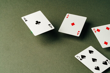 Playing cards on green background studio shot