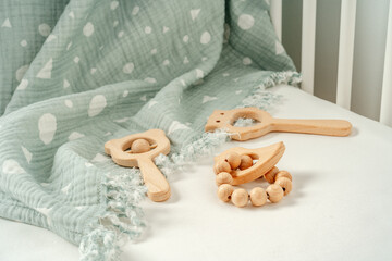 Toys and muslin soft blanket in baby bed close up