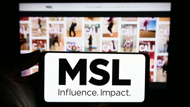 Stuttgart, Germany - 10-28-2023: Person holding smartphone with logo of French public relations company MSLGROUP in front of website. Focus on phone display.