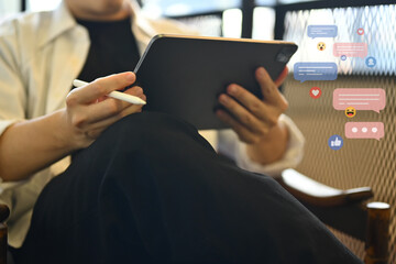 Casual young man freelancer using digital tablet for communicating in social media app