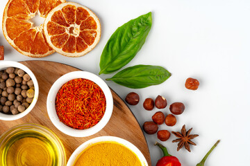 Bowls with spices on wooden board on white background