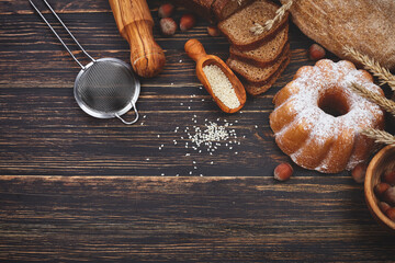 Fresh homemade bread and cake with sugar crispy baking on rustic wooden boards surface spilled...