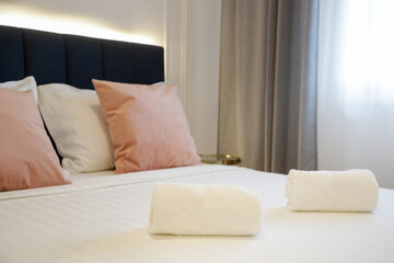 Fototapeta na wymiar Clean towels on bed in modern interior bedroom