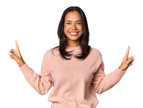 Young Filipina with long black hair in studio indicates with both fore fingers up showing a blank space.