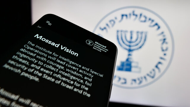Stuttgart, Germany - 10-29-2023: Mobile phone with webpage of Israeli national intelligence agency Mossad in front of logo. Focus on top-left of phone display.