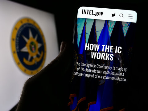 Stuttgart, Germany - 10-29-2023: Person holding cellphone with webpage of agency group United States Intelligence Community (IC) with seal. Focus on center of phone display.