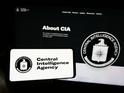 Stuttgart, Germany - 10-29-2023: Person holding mobile phone with logo of American Central Intelligence Agency (CIA) in front of web page. Focus on phone display.