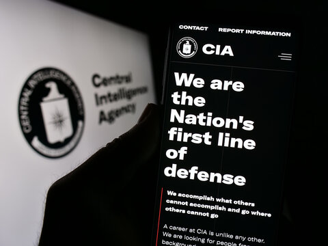 Stuttgart, Germany - 10-29-2023: Person holding cellphone with website of US Central Intelligence Agency (CIA) in front of seal. Focus on center of phone display.