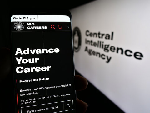 Stuttgart, Germany - 10-29-2023: Person holding mobile phone with web page of US Central Intelligence Agency (CIA) in front of logo. Focus on center of phone display.