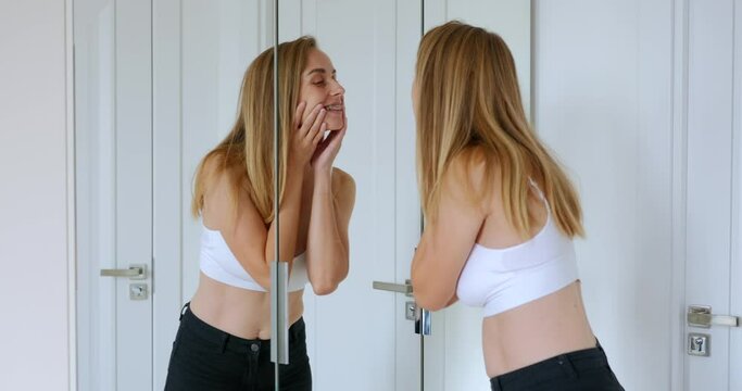 Young woman cheking her new braces in the mirror
