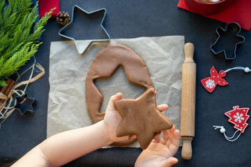 Kid making gingerbread cookies for christmas and new year
