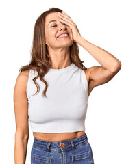 Middle-aged woman portrait in studio setting laughing happy, carefree, natural emotion.