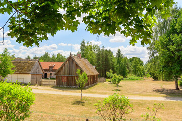 Fototapeta na wymiar Small cozy houses. Wooden ancient buildings. Summer village and vacation. Farm bio products.