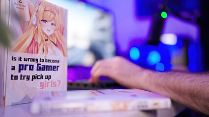 Anime gamer girl manga comic on table while headless person gaming in background - obrazy, fototapety, plakaty