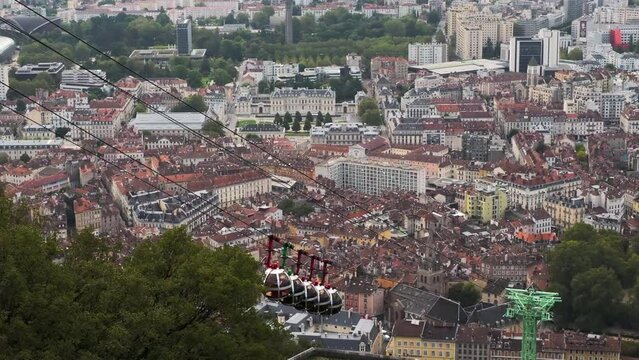 The cityscape of Grenoble and the funicular cabins arriving to Bastille