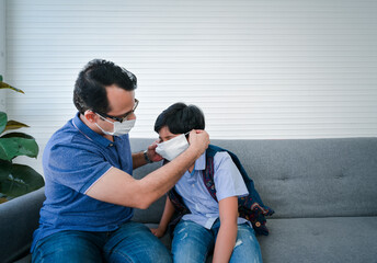 Indian father help his son wearing medical mask to protect Coronavirus covid-19 infected and he teach his son for the method to complete wearing the medical mask.