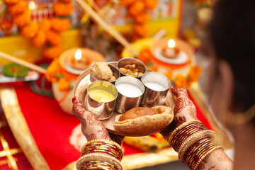 An Indian woman performing puja rituals with a plate of 'Prasadam'. Indian Hindu puja background.
