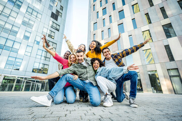 Multi ethnic young people smiling together at camera outdoors - Happy group of friends having fun hanging out in downtown street - University students standing together in college campus - obrazy, fototapety, plakaty