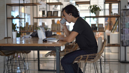 Asian freelancer online internet work home office. Boss guy use macbook computer indoor. Busy male man start up freelance job. User person sit inside cafe place. People study distant. Business laptop.