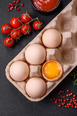 Raw chicken eggs in a box, cherry tomatoes, chickpeas, spices, salt and herbs
