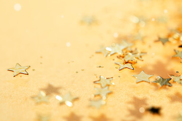 Golden stars scatter and glitter sparking. Blinking confetti celebration on yellow background....
