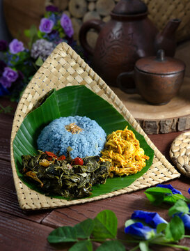 The blue colour of Nasi Kerabu comes from the petals of the butterfly pea flower. The rice is served with spiced shredded chicken and fried cassava leaves.