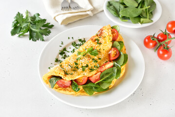 Breakfast omelette with spinach and tomato